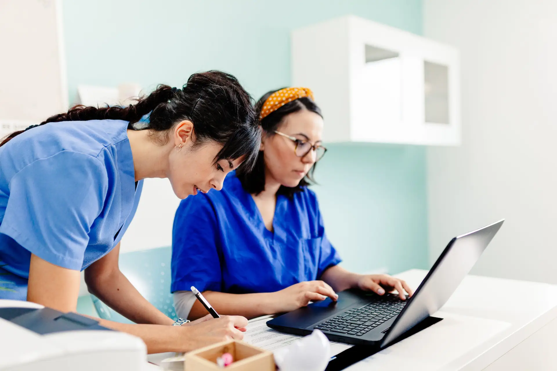 Female doctor and nurse using the laptop in the clinic